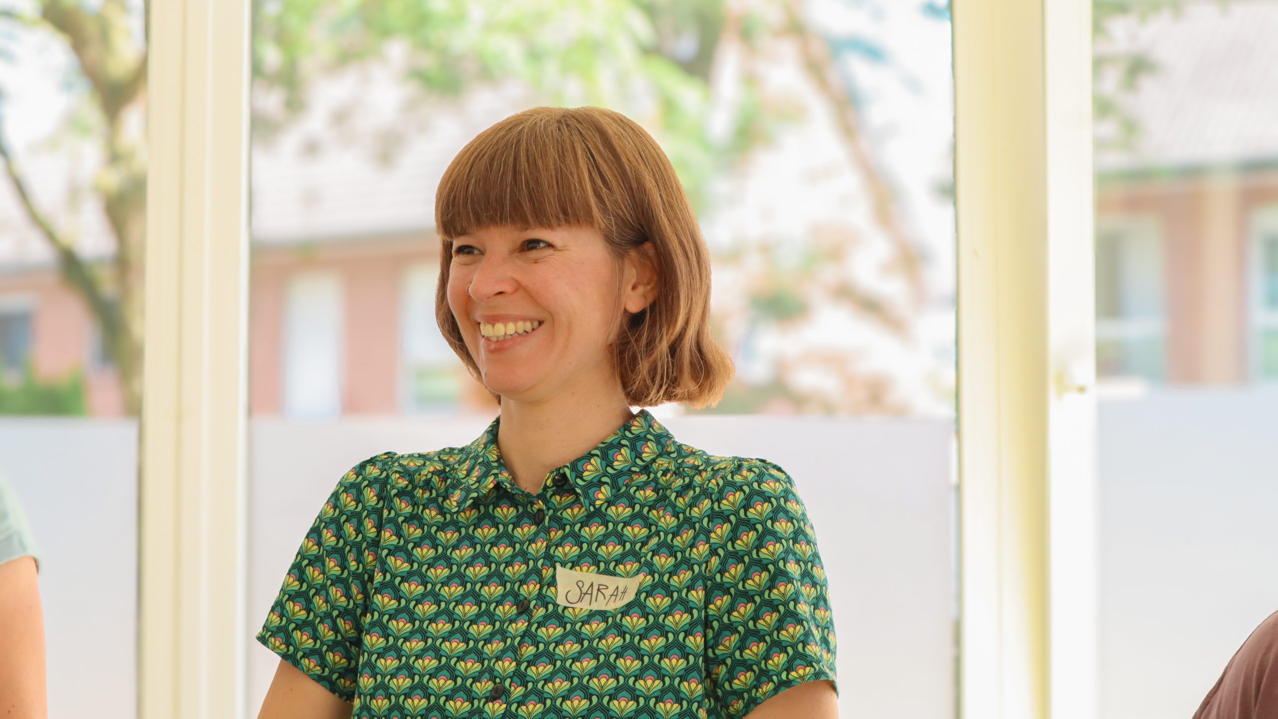 Sarah lacht mit Teilnehmenden